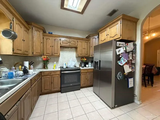 a kitchen with stainless steel appliances granite countertop a refrigerator and a sink