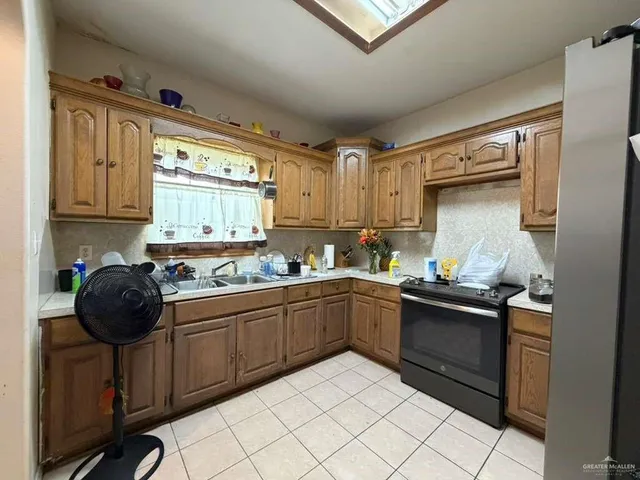 a kitchen with granite countertop a sink stainless steel appliances and cabinets