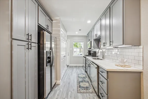 a kitchen with stainless steel appliances granite countertop a sink and refrigerator