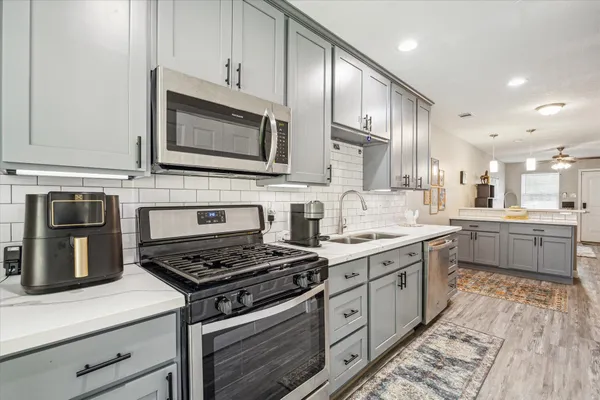 a kitchen with stainless steel appliances a stove microwave and cabinets