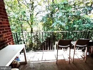 a balcony with table and chairs and potted plants