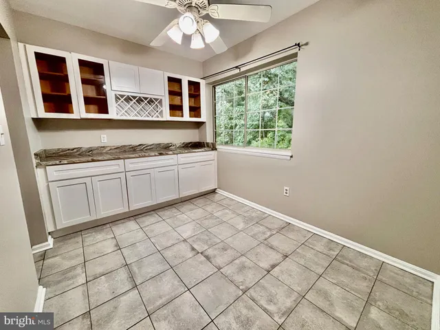 a large white kitchen with a sink and cabinets