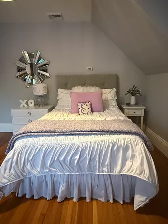 a bedroom with a bed and painting on the wall