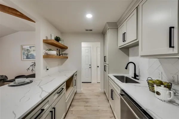 a kitchen with stainless steel appliances a sink stove and cabinets