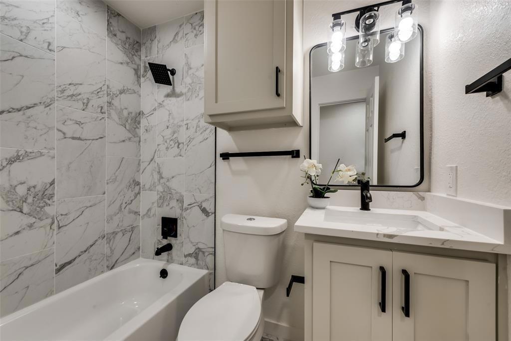 9227 Crimnson Court Dallas, TX 75217 - Photo 8 of 9 Bathroom with vanity, shower / bath combination, and a textured wall