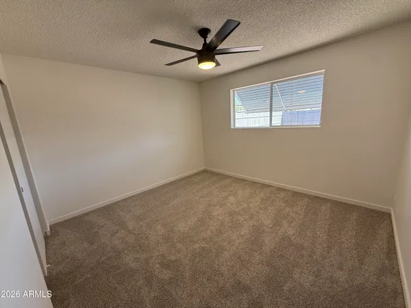 an empty room with fan and entrance