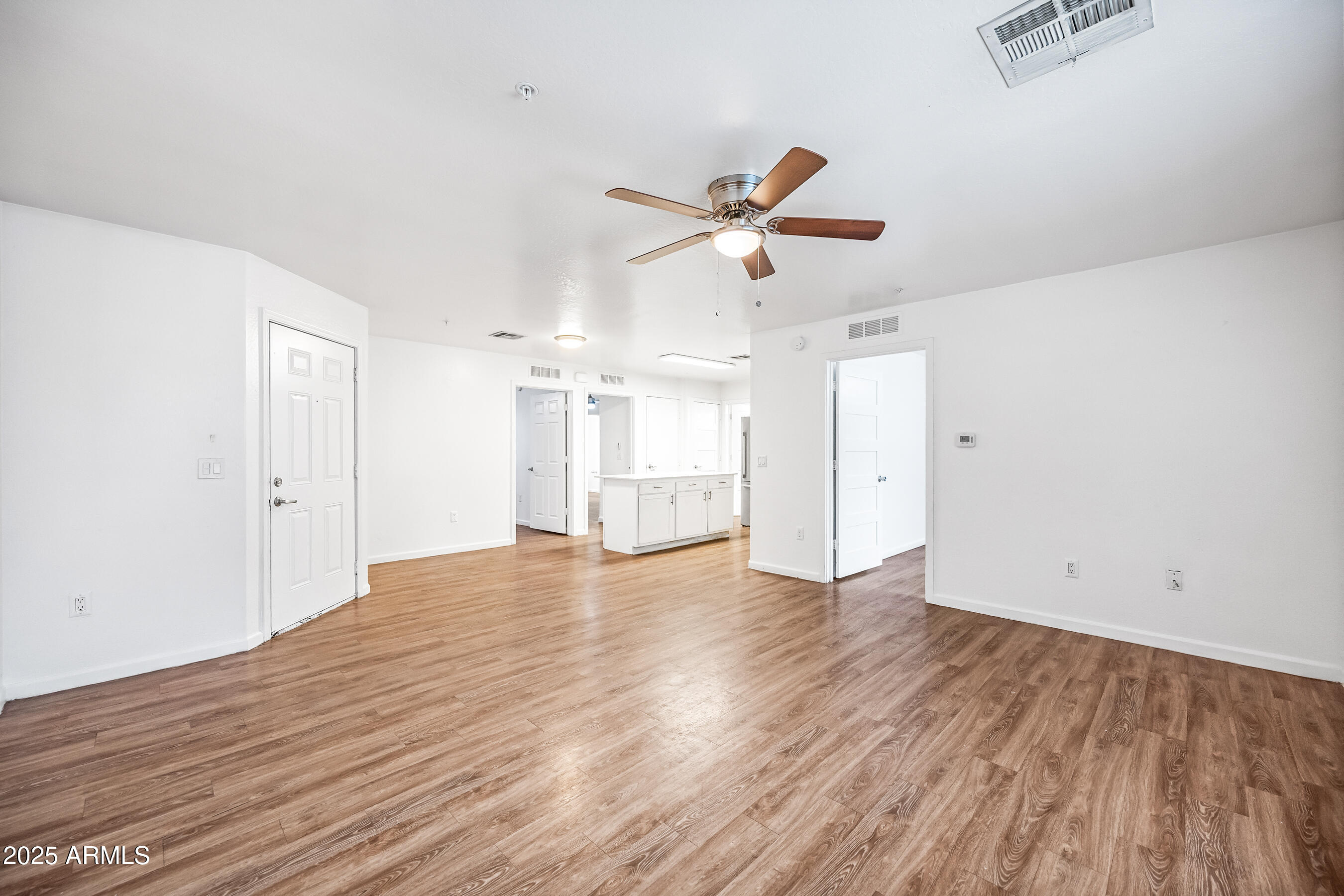 3065 North 67th Avenue, Unit 135 Phoenix, AZ 85033 - Photo 5 of 30 an empty room with wooden floor and windows