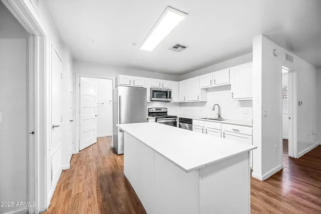 a kitchen with a sink a stove and cabinets
