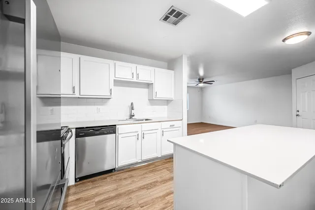 a kitchen with cabinets stainless steel appliances a sink and cabinets