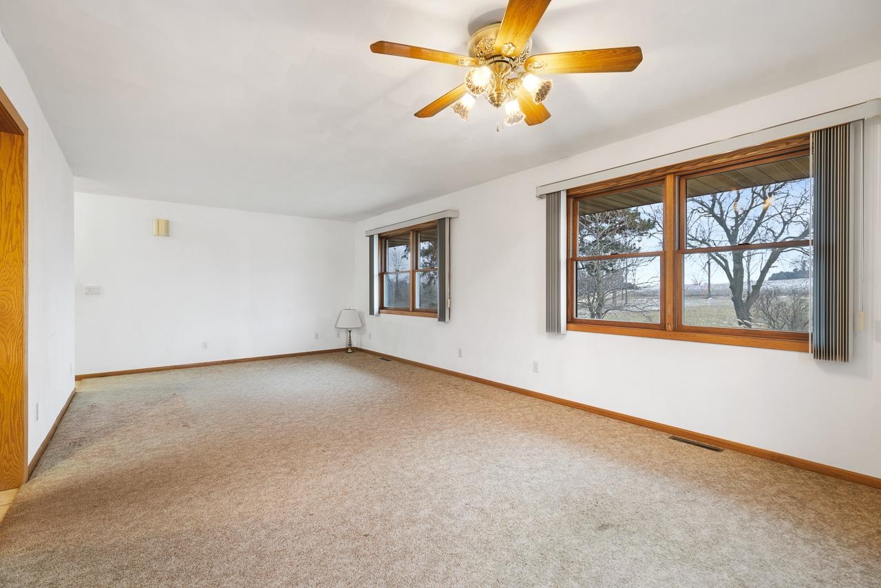 3178 North Berlin School Road Ridott, IL 61067 - Photo 19 of 47 an empty room with windows and chandelier fan