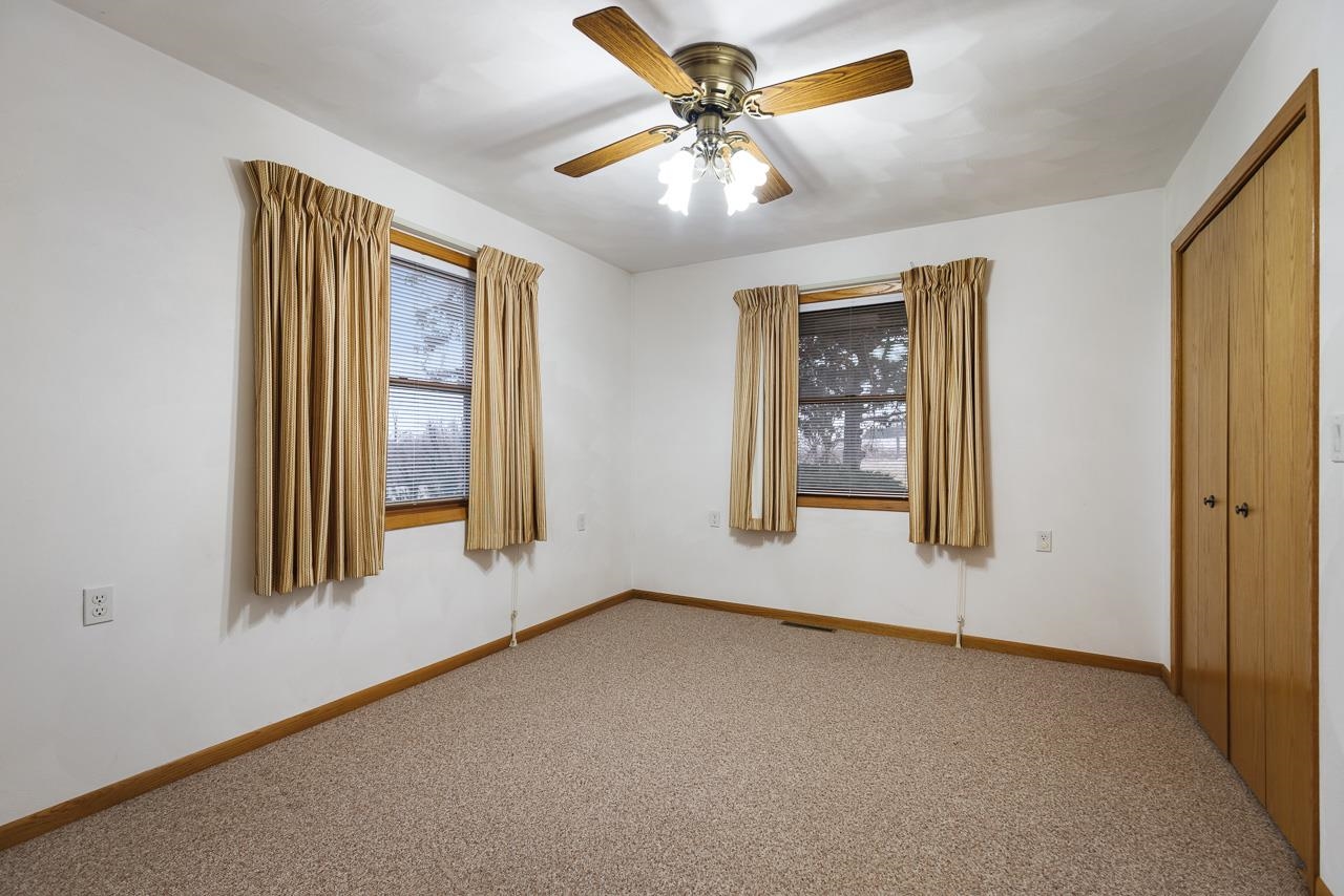 3178 North Berlin School Road Ridott, IL 61067 - Photo 23 of 47 an empty room with windows and fan