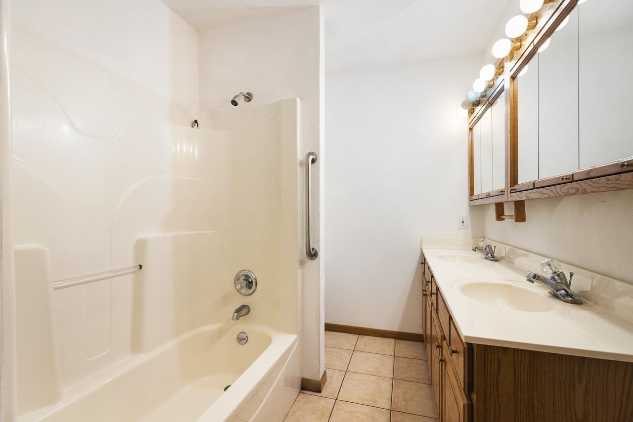 3178 North Berlin School Road Ridott, IL 61067 - Photo 25 of 47 a bathroom with a bathtub a shower a sink and a mirror