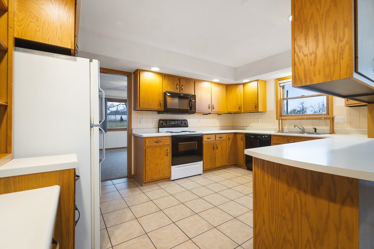 3178 North Berlin School Road Ridott, IL 61067 - Photo 10 of 47 a kitchen with stainless steel appliances a stove a sink and a refrigerator