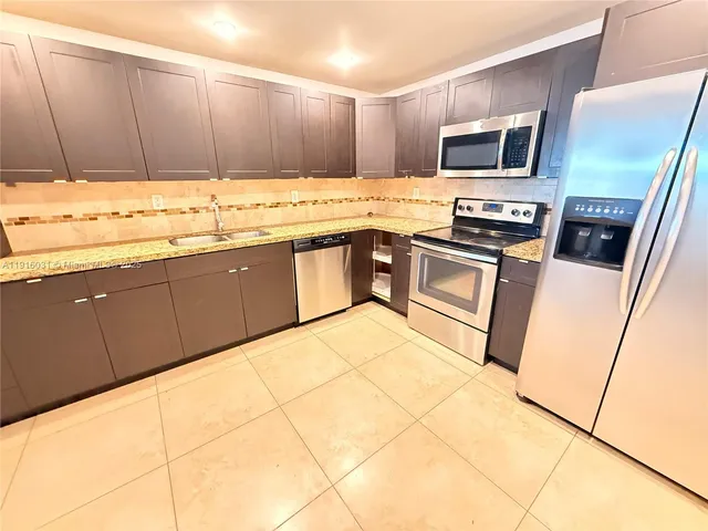 a kitchen with stainless steel appliances a stove a sink and a microwave