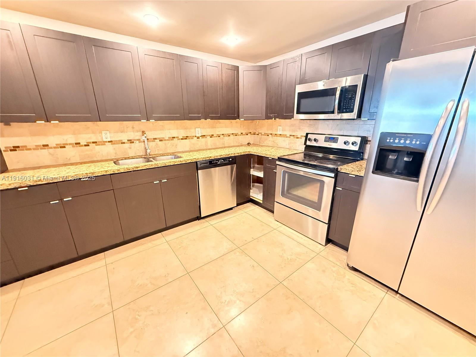 a kitchen with stainless steel appliances a stove a sink and a microwave