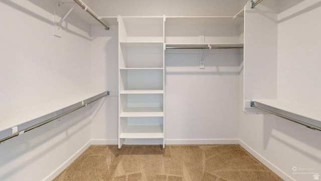 783 Pheasantbrook Drive, Unit 2A Centerville, UT 84014 - Photo 35 of 41 Walk-in closet featuring built-in shelving, multiple hanging rods, and neutral-toned carpeting