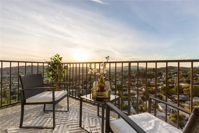 a view of a balcony with chairs and wooden floor