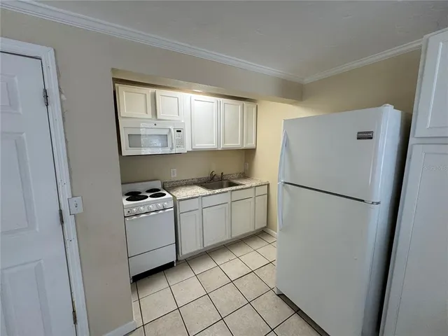 a kitchen with a refrigerator sink stove and cabinets