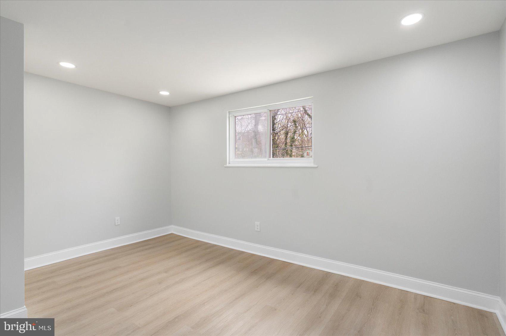 4002 Derby Manor Drive Baltimore, MD 21215 - Photo 16 of 32 an empty room with wooden floor and window