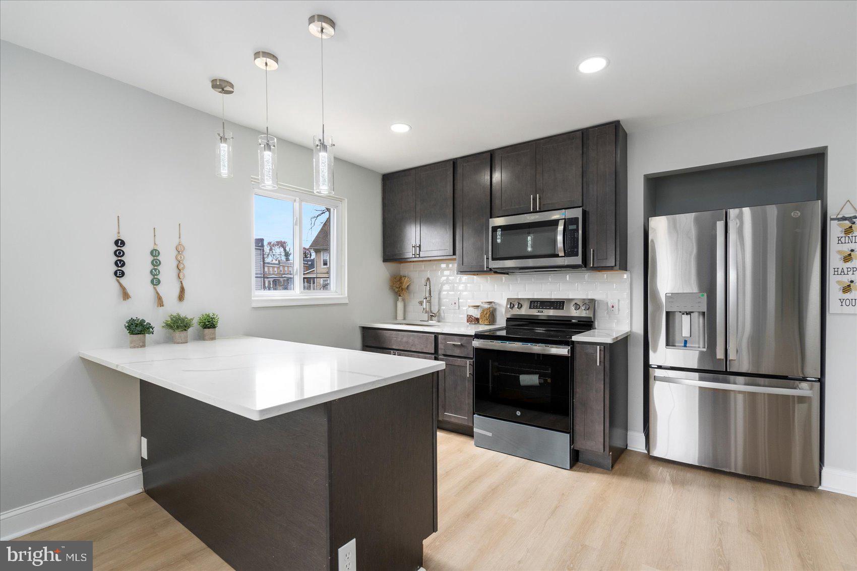 4002 Derby Manor Drive Baltimore, MD 21215 - Photo 2 of 32 a kitchen with granite countertop a refrigerator oven a sink and dishwasher