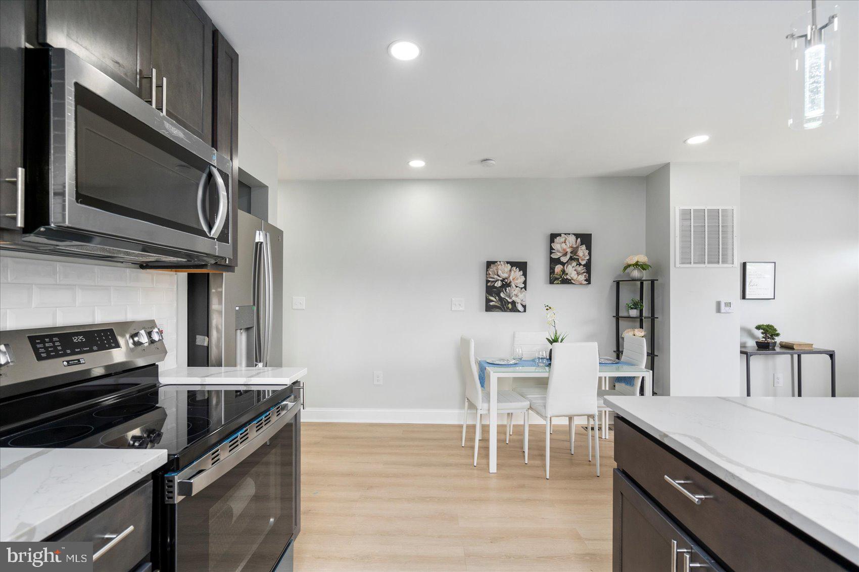 4002 Derby Manor Drive Baltimore, MD 21215 - Photo 10 of 32 a kitchen with stainless steel appliances kitchen island granite countertop a stove and a microwave