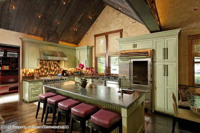 a kitchen with a table chairs stove and cabinets