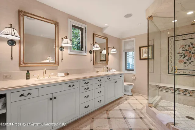 a bathroom with a double vanity sink a mirror a bathtub and window