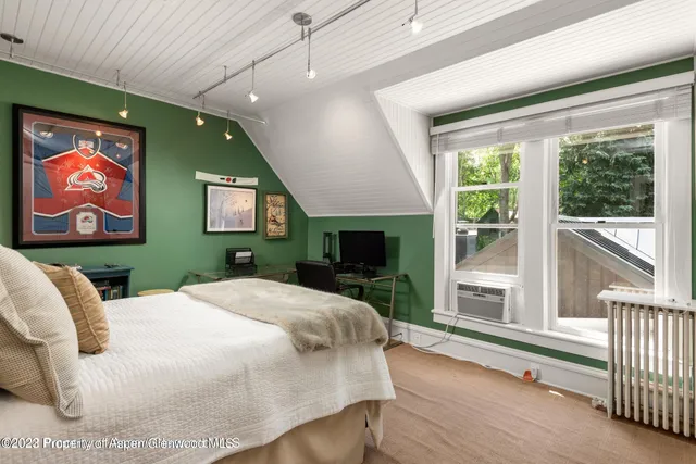 a spacious bedroom with a large bed and a flat screen tv