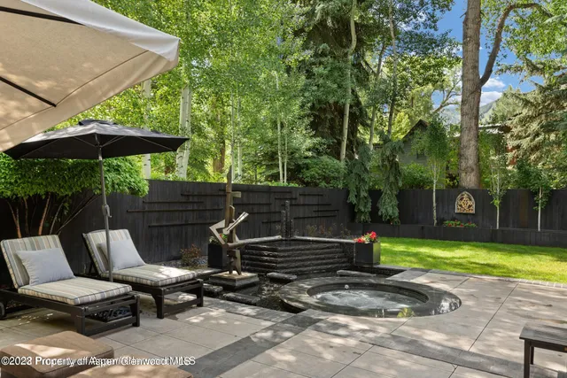 a view of a patio with a table and chairs under an umbrella