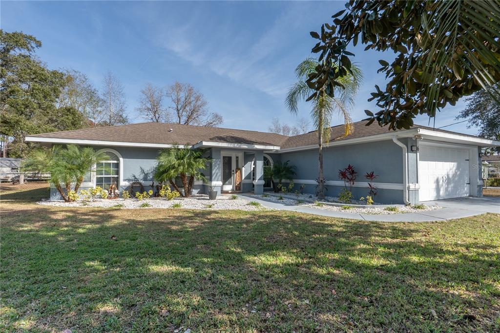6 Fir Drive Trace Ocala, FL 34472 - Photo 1 of 41 a front view of a house with a garden and patio