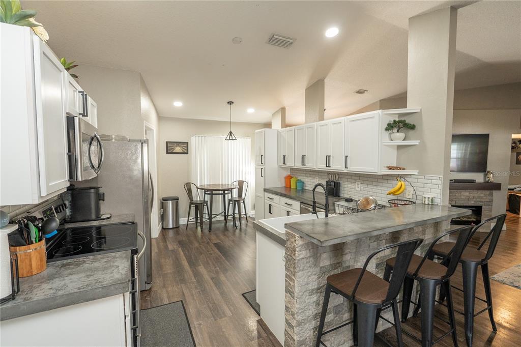 6 Fir Drive Trace Ocala, FL 34472 - Photo 9 of 41 a kitchen with stainless steel appliances granite countertop a stove top oven a sink a dining table and chairs