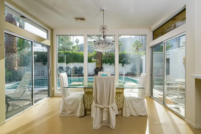 a dining room with wooden floor and windows
