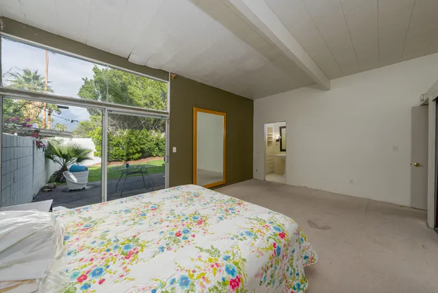 a bedroom with a bed and a large window