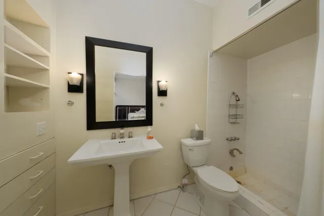 a bathroom with a toilet sink and mirror