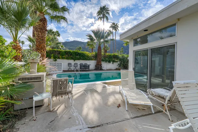 a view of a patio with couches table and chairs and potted plants