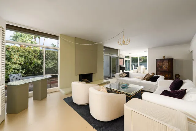 a living room with furniture a large window and a fireplace