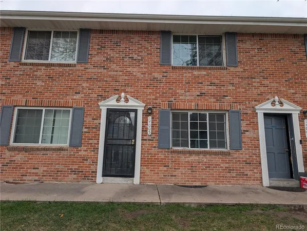 a brick house with a door and a yard