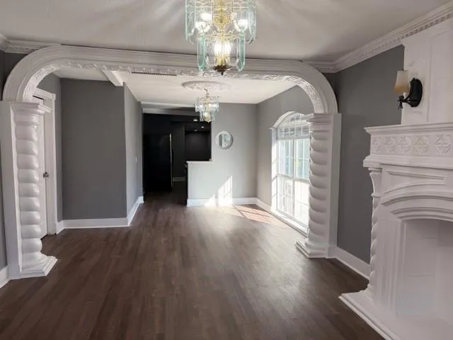 a view of a living room with wooden floor and chandelier