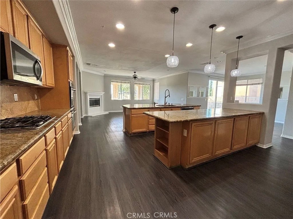 3715 Club Rancho Drive Palmdale, CA 93551 - Photo 7 of 52 a kitchen with stainless steel appliances granite countertop wooden floors and white cabinets