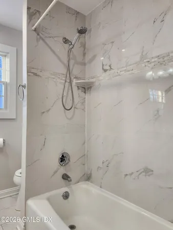 a bathroom with a bath tub with a shower