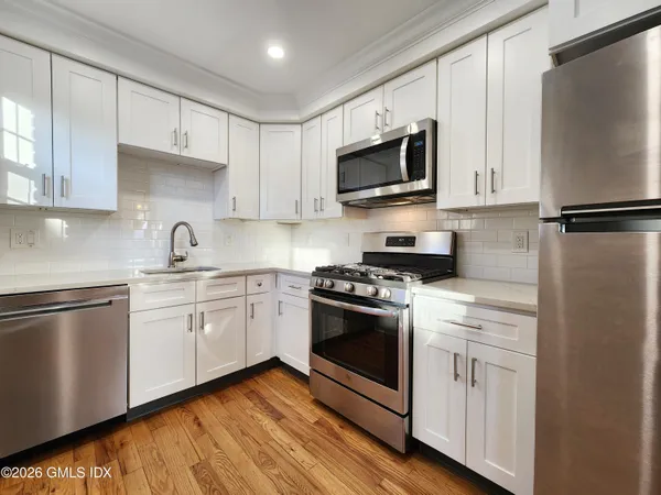 a kitchen with white cabinets stainless steel appliances and sink