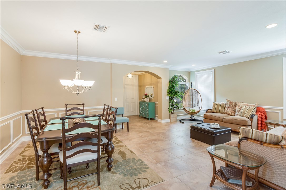 8517 Sumner Avenue Fort Myers, FL 33908 - Photo 6 of 25 a living room with furniture a chandelier and a large window