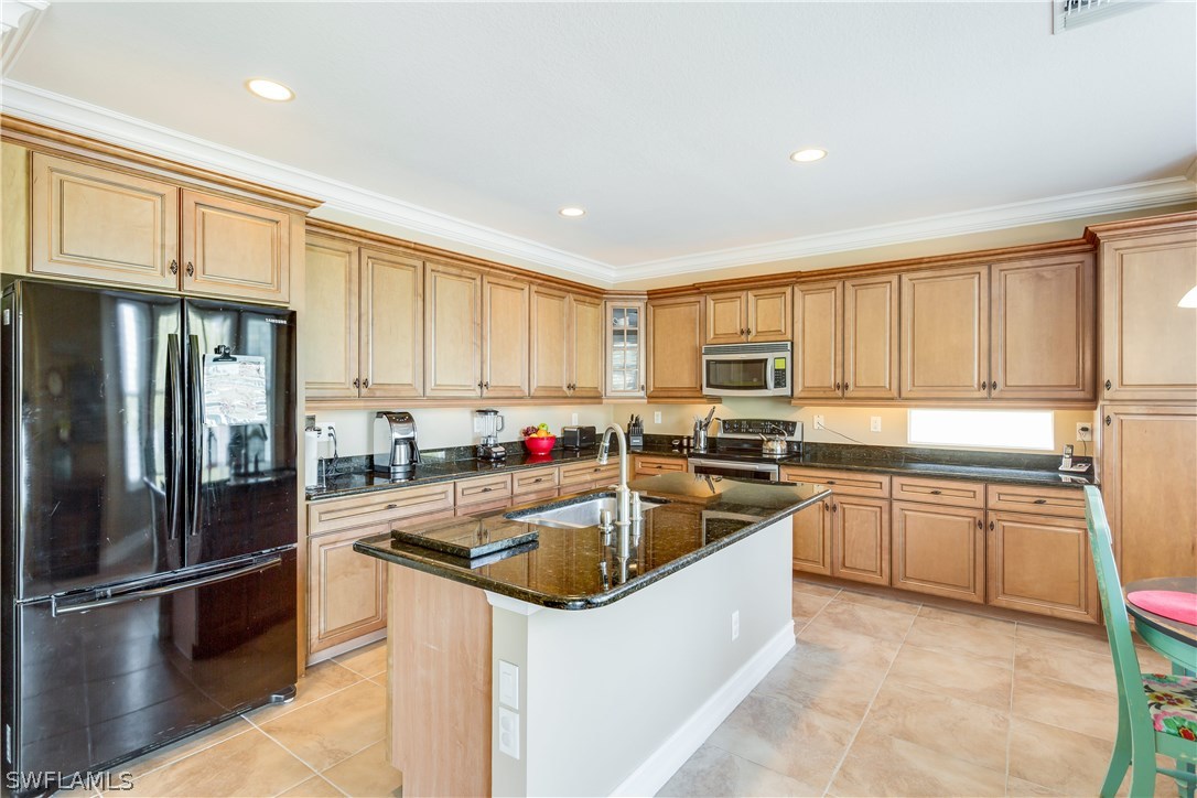 8517 Sumner Avenue Fort Myers, FL 33908 - Photo 8 of 25 a kitchen with granite countertop a refrigerator sink and cabinets