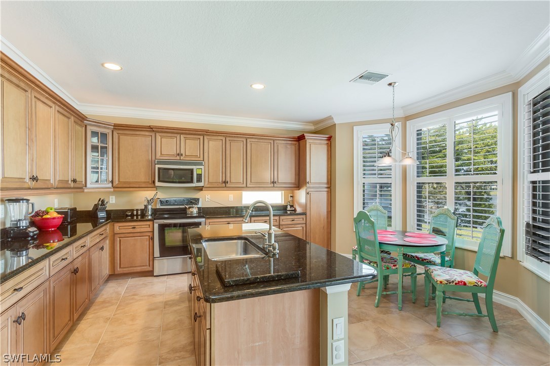 8517 Sumner Avenue Fort Myers, FL 33908 - Photo 9 of 25 a kitchen with stainless steel appliances granite countertop sink stove top oven and cabinets
