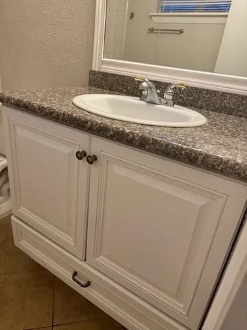 a bathroom with a granite countertop toilet sink and mirror