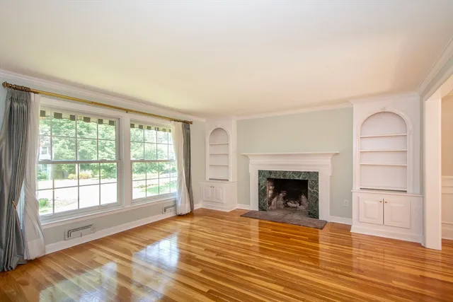 wooden floor fireplace and windows in an empty room