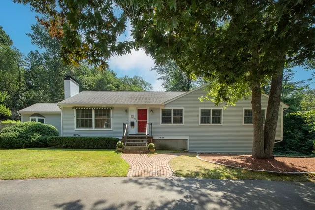 a front view of house with yard and trees around