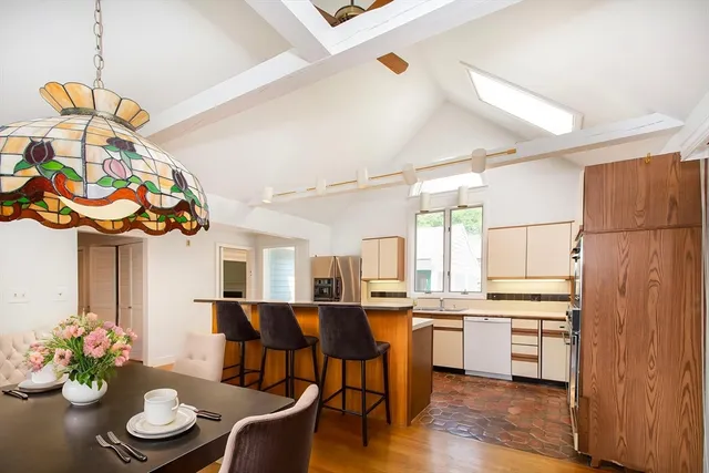 a kitchen with stainless steel appliances kitchen island granite countertop a refrigerator and a dining table