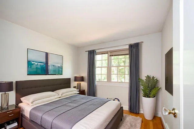 a bedroom with a bed potted plant with the window