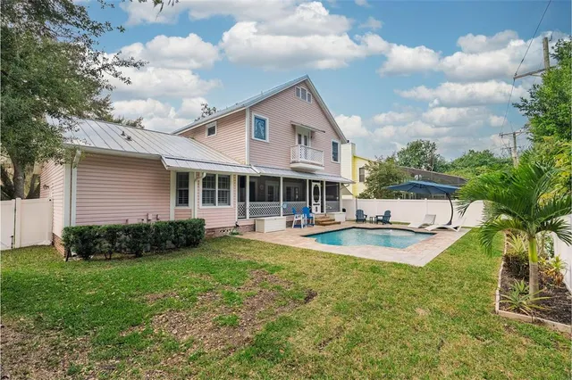 front view of a house with swimming pool and porch with furniture